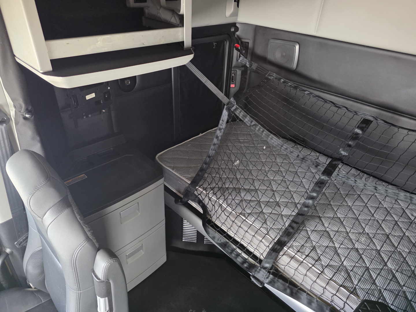 Kenworth T680 interior sleeper area with raised bunk and storage drawers visible
