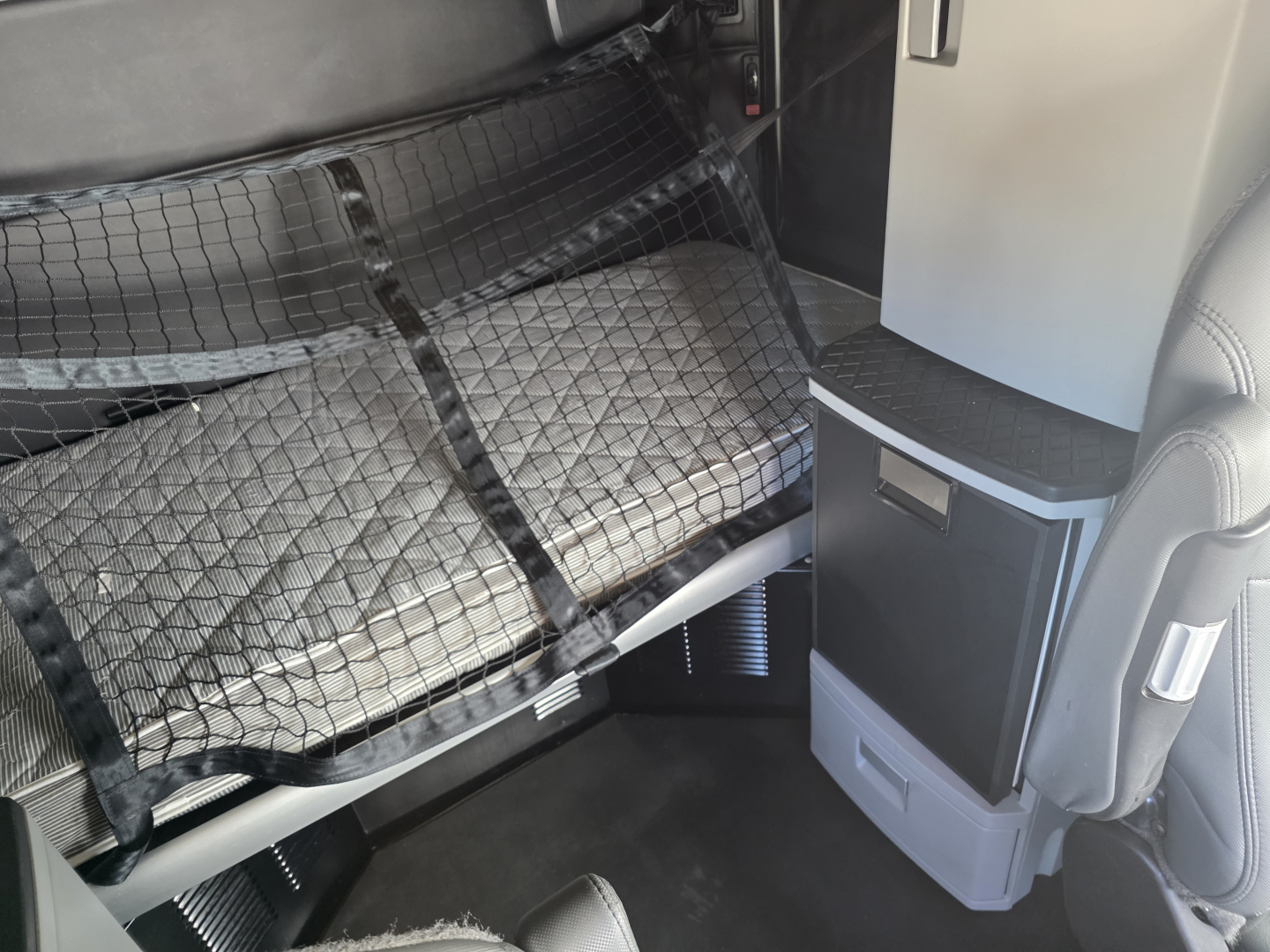 Kenworth T680 interior cab with storage compartments and sleeper berth visible.