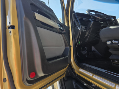 Kenworth T680 truck cab interior with open door showing steering wheel and dashboard.
