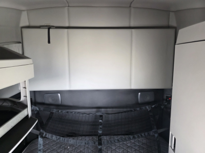 Kenworth T680 interior cargo area with sleeper cab partition and cargo nets; text not visible in image.
