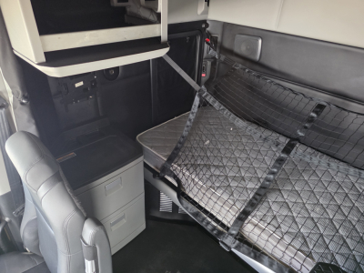 Kenworth T680 interior sleeper area with raised bunk and storage drawers visible
