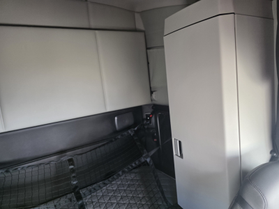 Kenworth T680 interior cargo area showing storage cabinet and passenger seat in-vehicle view.