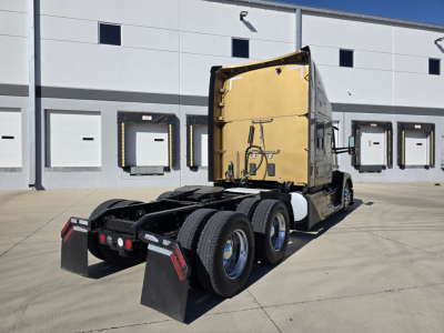 Kenworth T680 truck tractor chassis with sleeper cab, rear view showing dual rear axles and mud flaps.