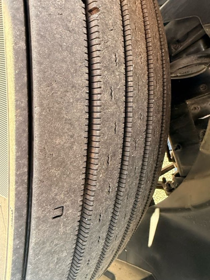 Front dual drive tires of a Mack AN64T70 truck showing tread pattern and sidewall details.