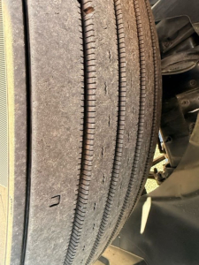Front dual drive tires of a Mack AN64T70 truck showing tread pattern and sidewall details.