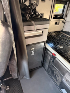 Conventional sleeper truck cab interior showing storage drawer unit and entry area in a Mack AN64T70 with visible flooring and steps.