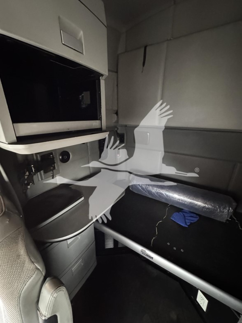 Cab interior of 2016 Kenworth T680 showing storage area, overhead compartments, and a padded bunk/seat with a rolled insulation sleeve. Visible text not legible beyond generic interior features.
