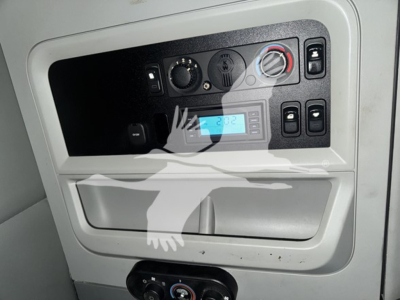 Dashboard panel of a Kenworth T680 showing climate control dial, digital display, and small storage pocket.