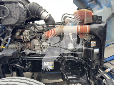 Kenworth T680 engine bay showing turbocharger hose, coolant reservoir, and various engine components with wiring and hoses visible.