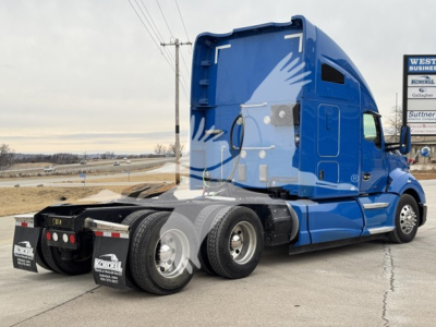Kenworth T680 tractor in blue sleeper cab, side view showing rear wheels and APUs area.