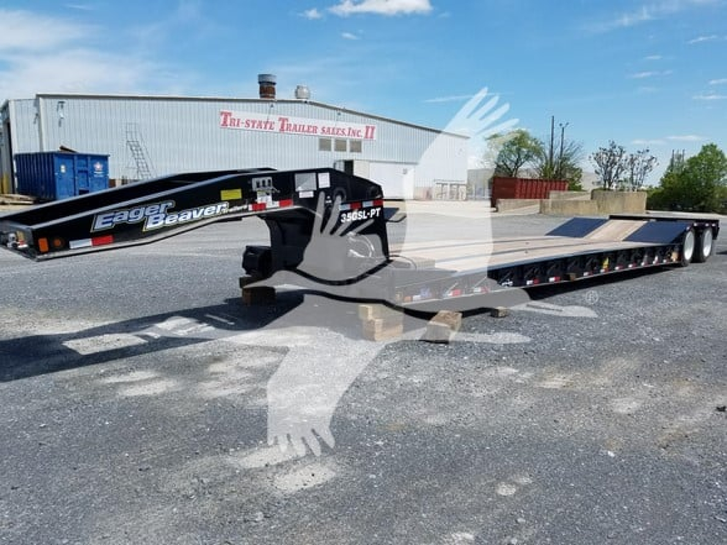 Lowboy trailer in a dealership lot showing Eager Beaver 35Gsl PT model with black gooseneck section and long flatbed, brand markings visible.