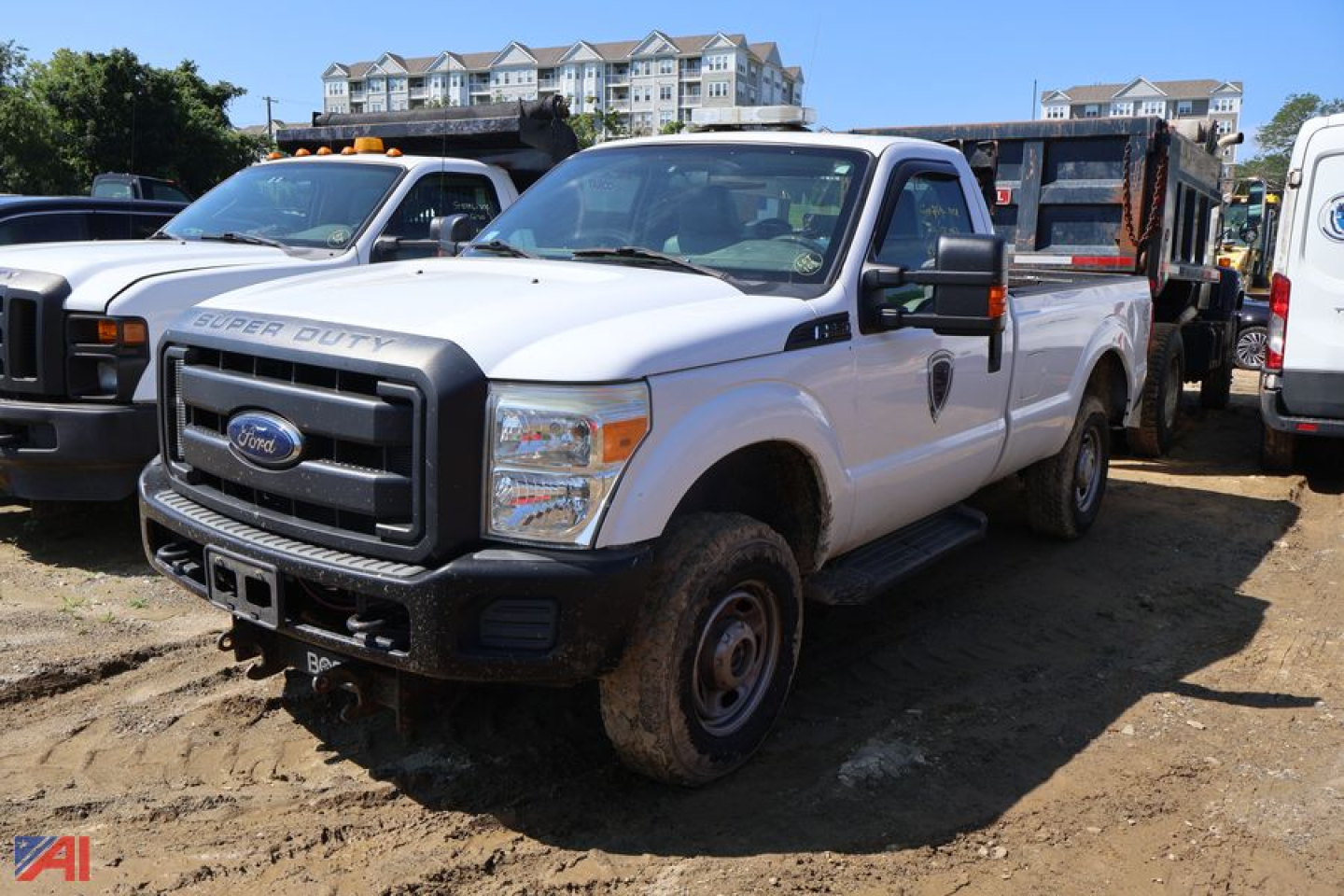 Ford F-250 Super Duty pickup truck with plow attachment in a gravel lot, white crew cab, front grille badge visible.