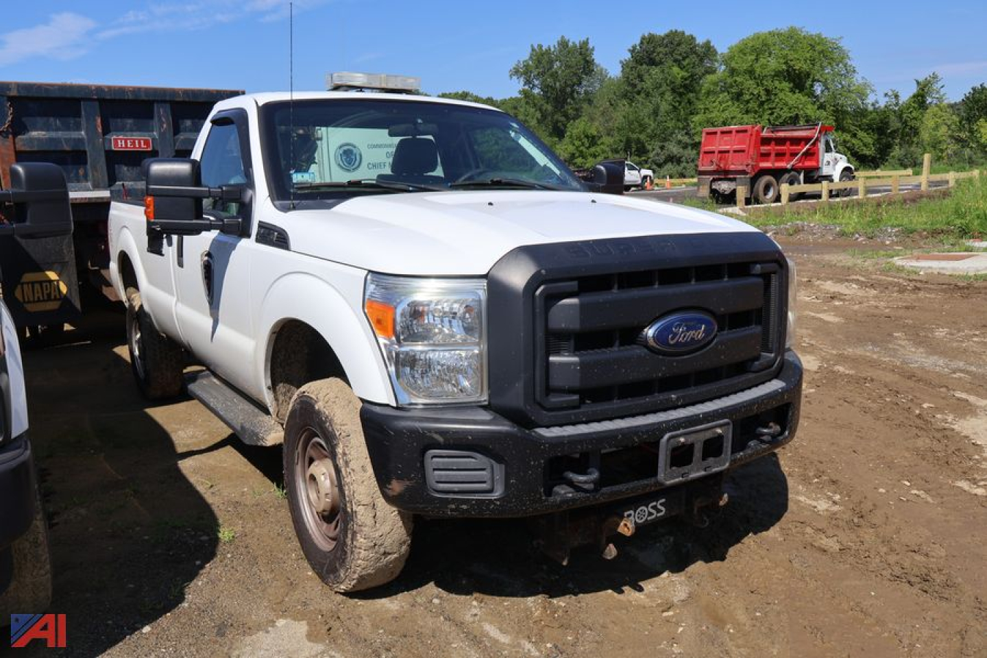 Ford F-250 Super Duty pickup with plow, white crew cab, front view, dirt yard, heavy-duty bumper, plow mount, side mirror extensions.