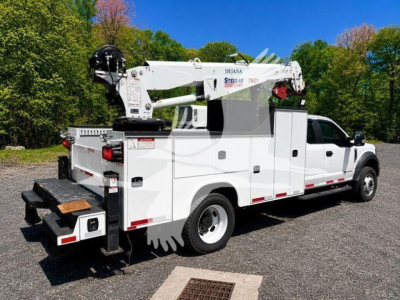 Ford F-550 utility service truck with crane, white body, side compartments, mounted boom crane labeled Dejana Stellar 7821.