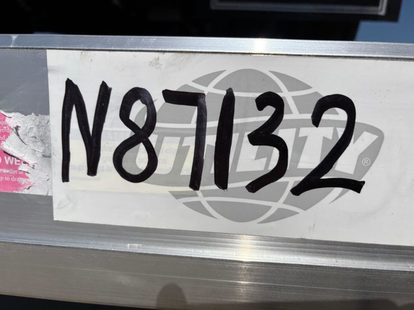 Trailer VIN plate showing N87132 stock number on metal surface.