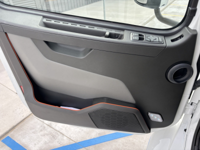 Volvo VHD cab interior door panel view showing window controls and speaker grille.