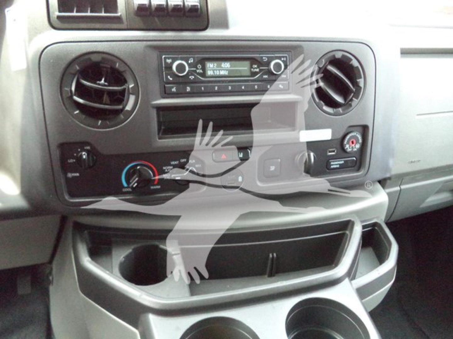 Ford E-Series cargo van dashboard with central radio, two circular vents, climate controls, and cup holders visible.