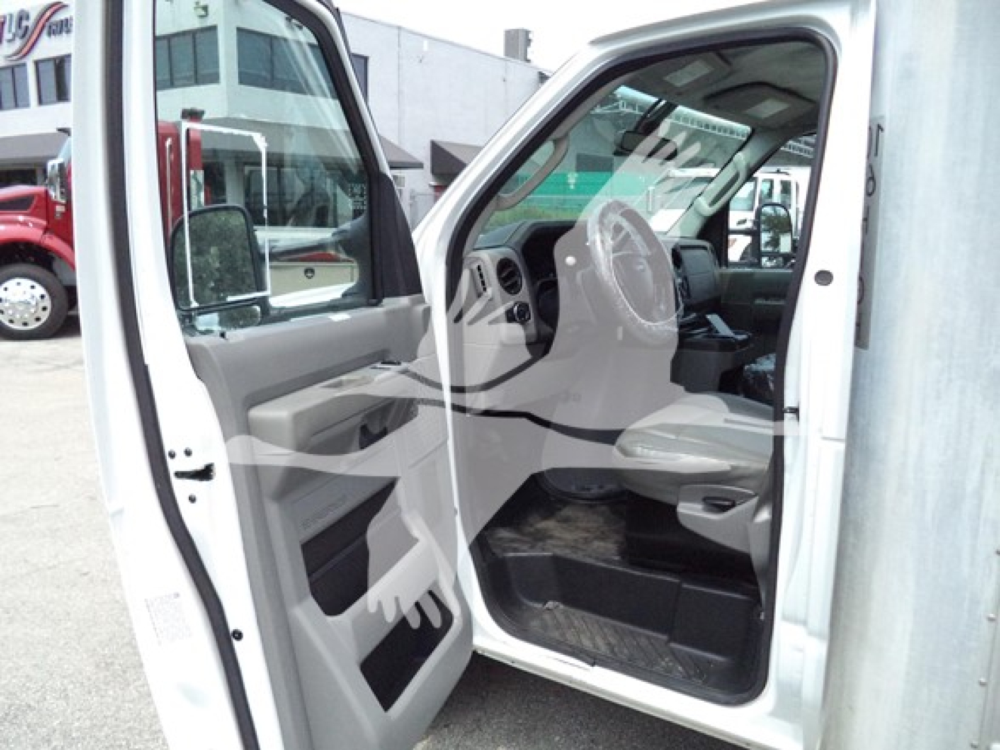 Ford E-Series van interior view from open driver's door showing dashboard steering wheel beige interior and floor mats