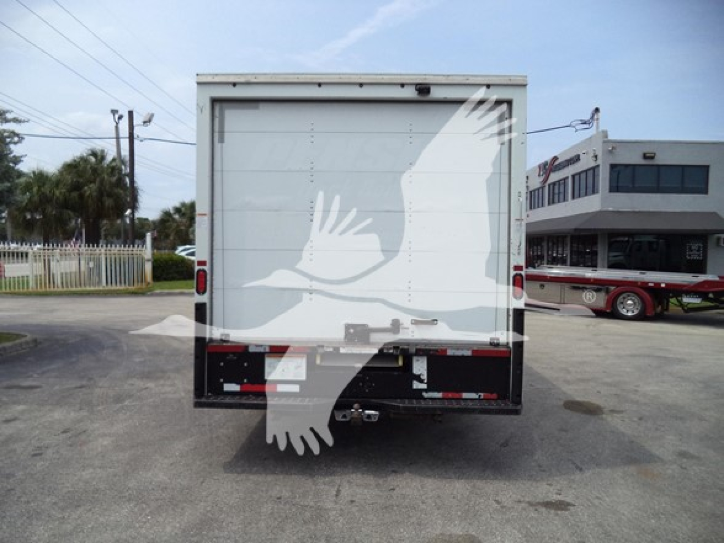 Rear view of a 2022 Ford E350 high cube cutaway box truck showing plain white back with diesel gate and tail lights.