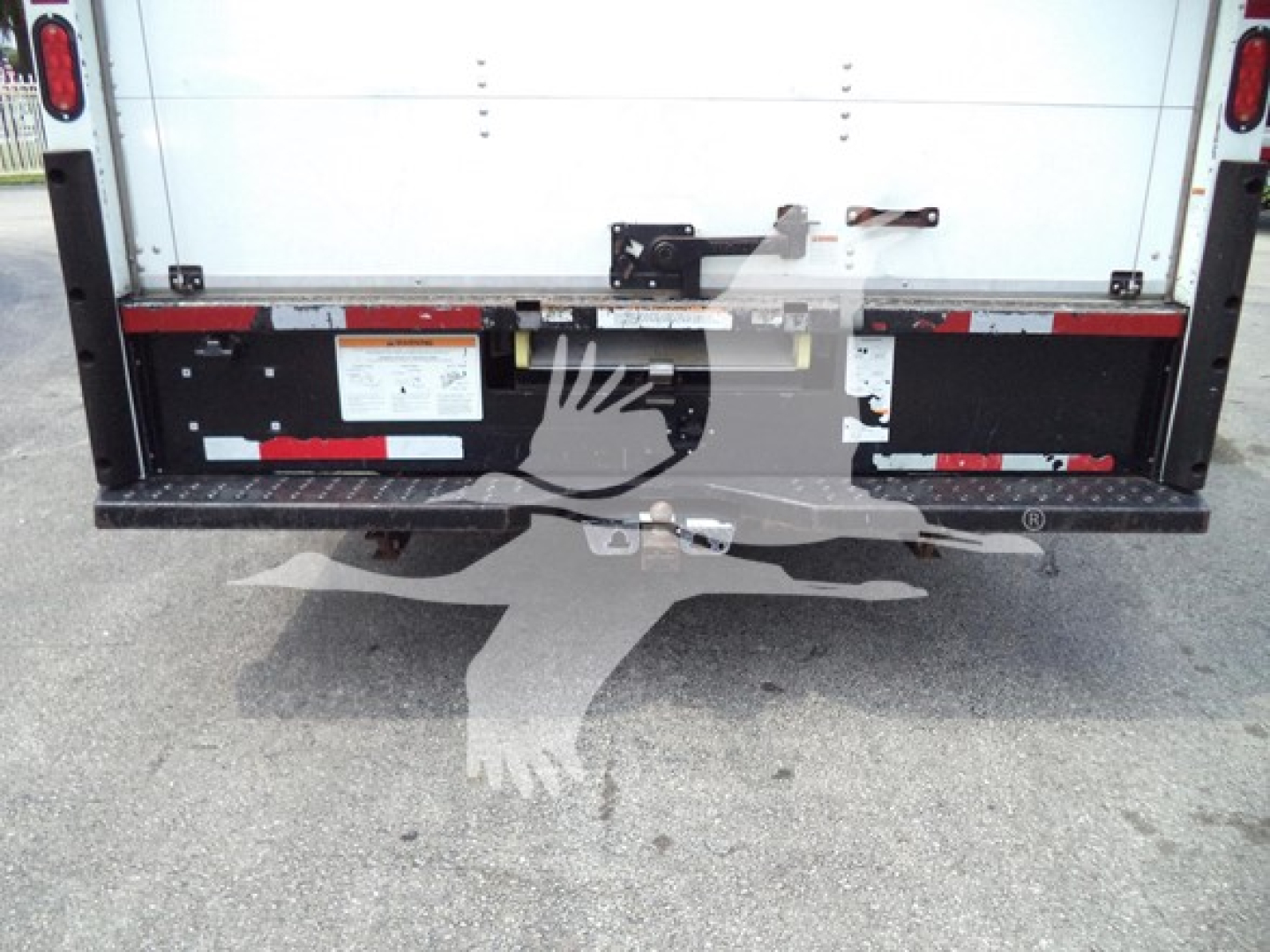 Ford E-350 rear view showing cargo door and hitch area with wiring and reflectors.