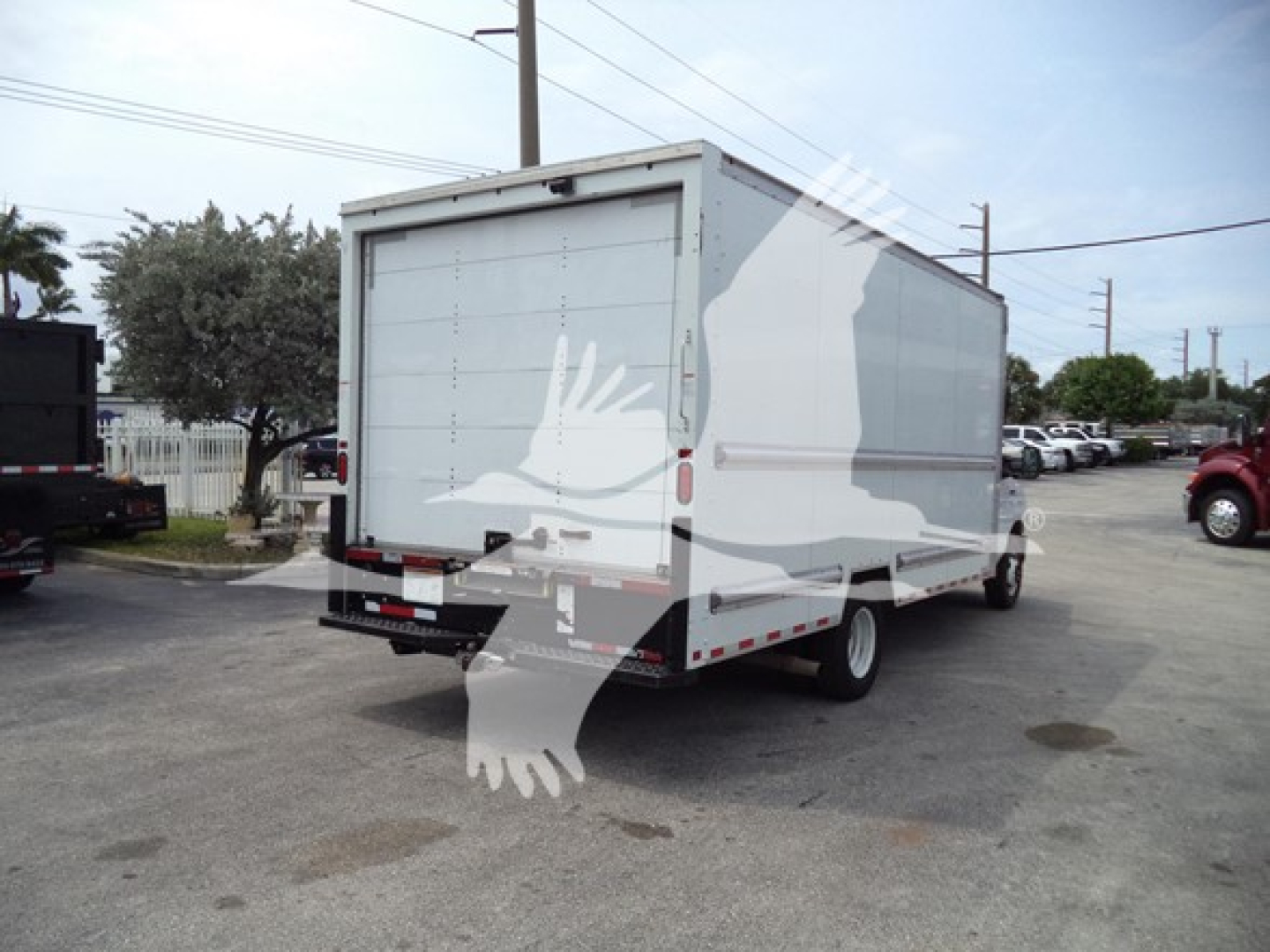 Ford E-350 utility box truck rear three-quarter view showing cargo box with side graphic and rear doors, VIN label not visible. 