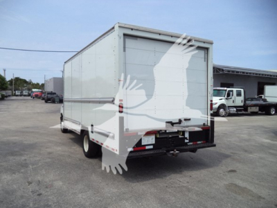 Ford E-350 box truck rear view showing cargo box and rear doors with truck yard in background.