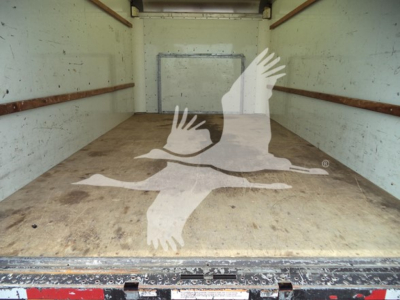 Truck cargo area of a 2022 Ford E350 showing empty bed with wood floor and logo watermark overlay.