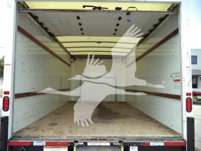 Ford E-350 cargo van interior empty cargo area with plywood floor and side rails.
