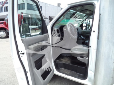 Ford E-Series van interior view from open driver's door showing dashboard steering wheel beige interior and floor mats