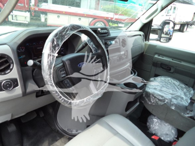 Ford E-350 interior view showing steering wheel and front seats with plastic covers