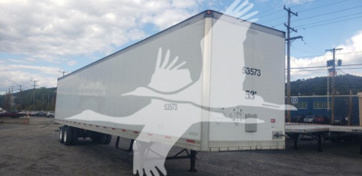 Trailer side view showing 53' dry van with registration numbers and rear doors, Trailmobile logo faded overlay.