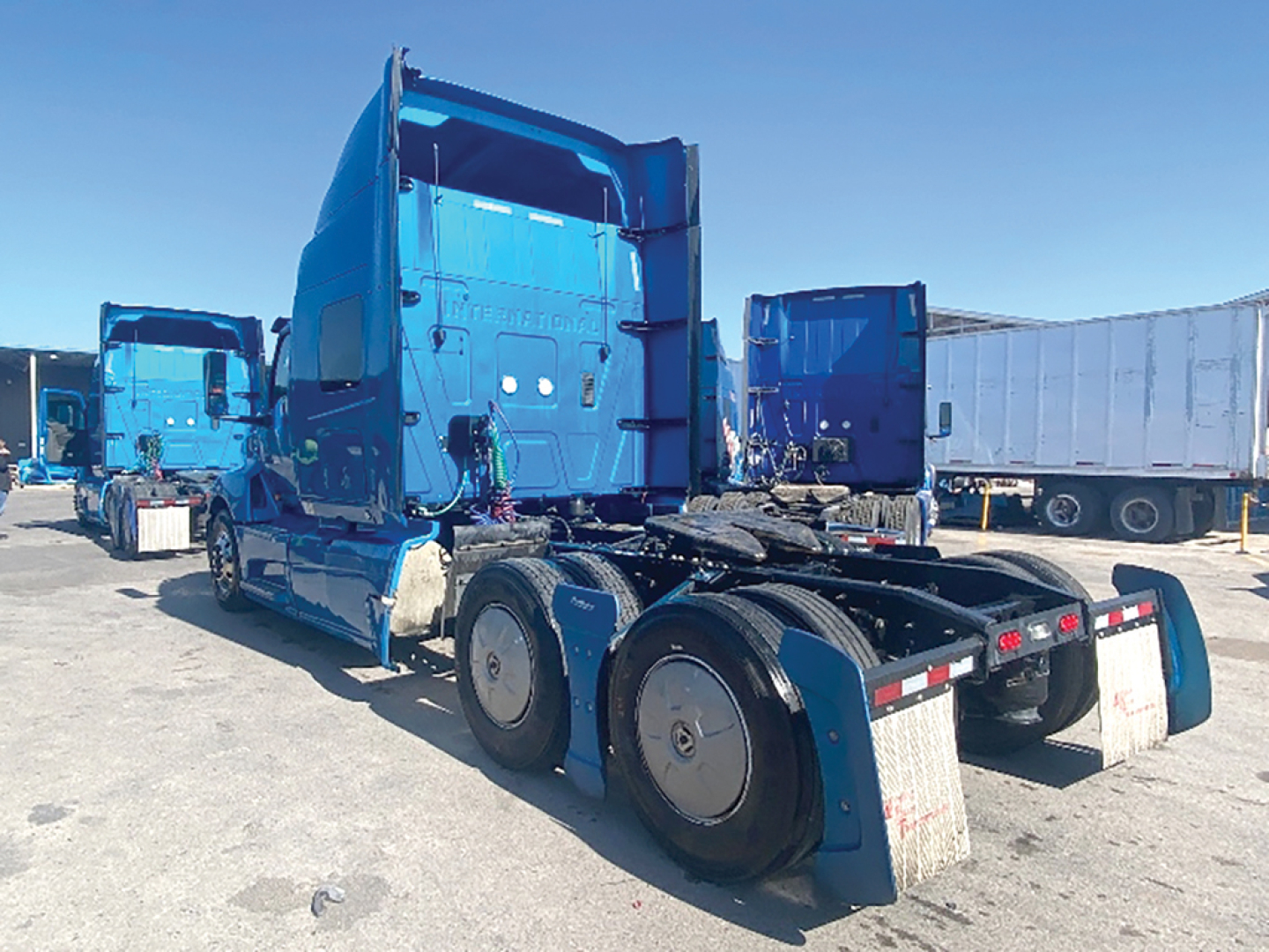 Truck tractor in blue showing rear tractor tandem and sleeper cab with dual rear axles.