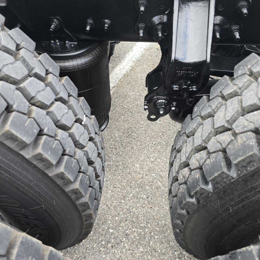 Mack PI64T truck rear dual wheels and chassis view showing heavy-duty tires and undercarriage components.
