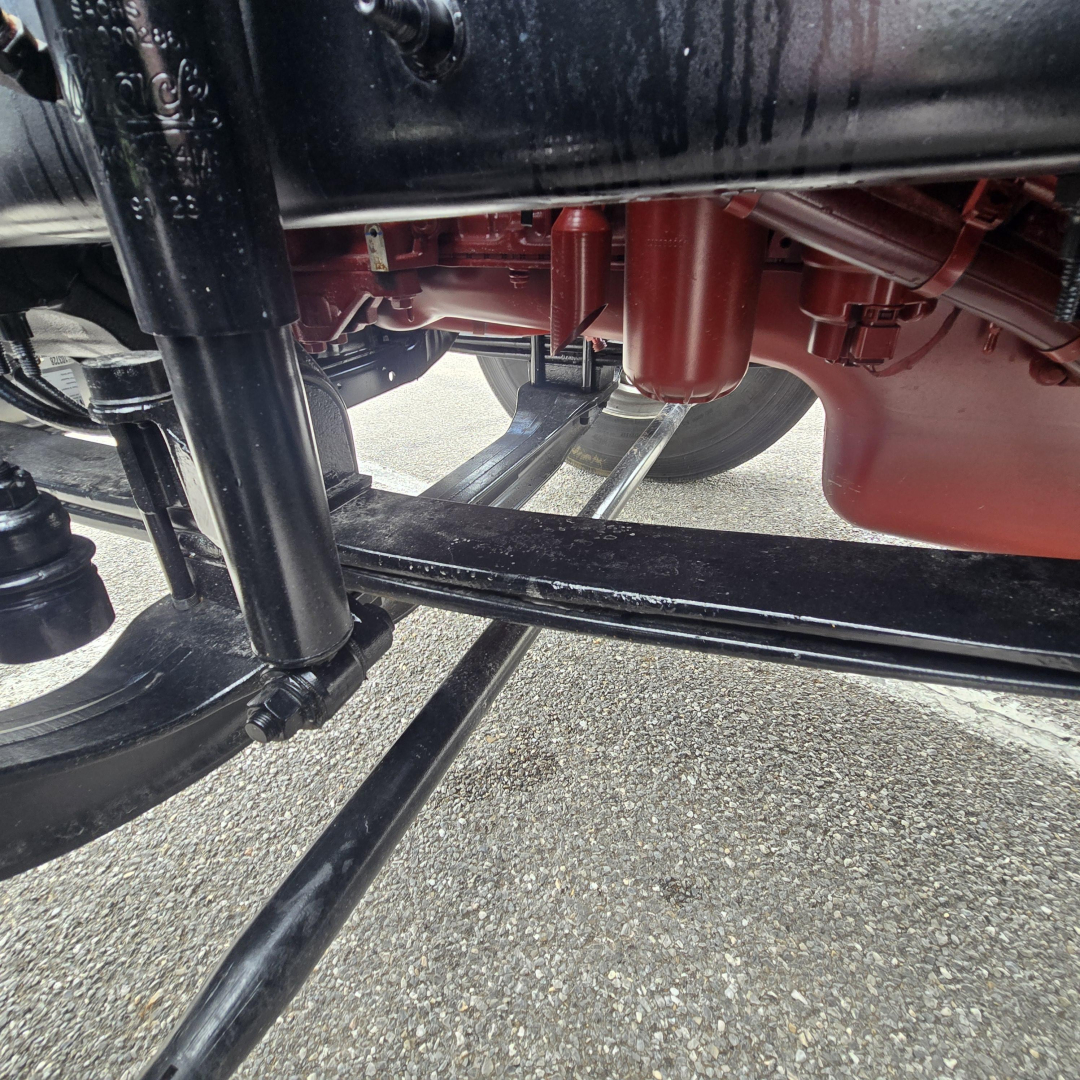 Underbody view of a 2027 Mack PI64T chassis showing suspension leaf springs and undercarriage components.