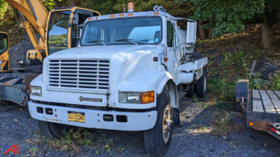 International 4900 sewer jet truck showing front with grille, headlights, bumper, and mounted water/tank body in a yard.