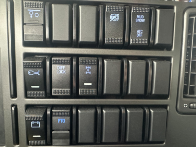 Dashboard switches and controls of a 2026 Mack GR84F truck showing difflock, PTO, mud/snow, and various toggle buttons.