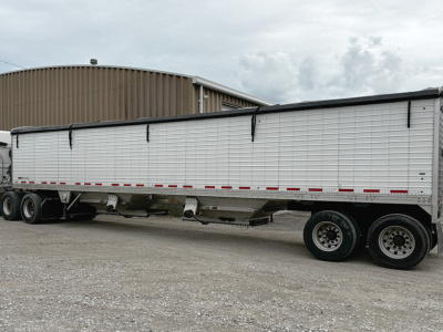 Trailer side view of a 2018 Timpte Super Hopper, white with silver-toned ribbed panels, triple-axle configuration, showing stock number 551176 and VIN JB157996.