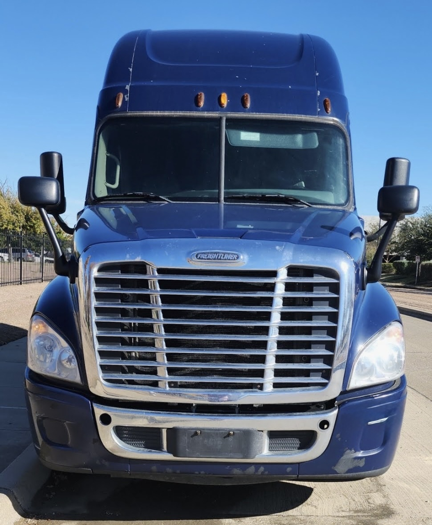 Front view of a blue 2015 Freightliner Cascadia sleeper cab truck showing large chrome grille and headlights.