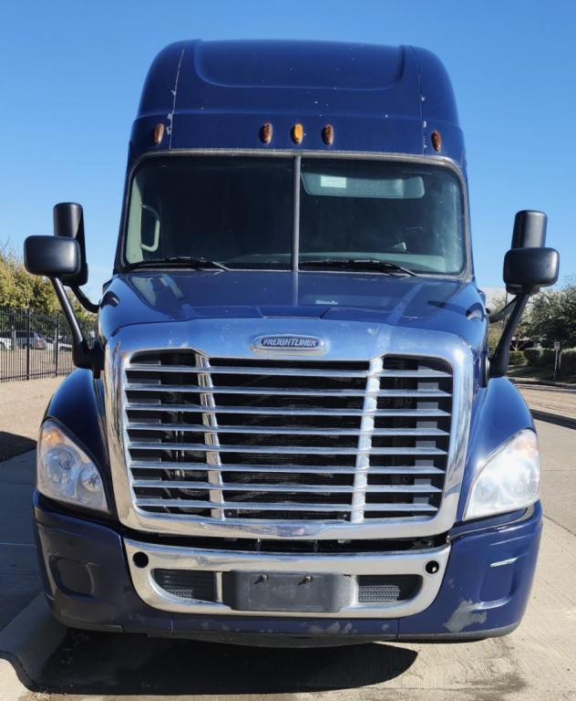 Front view of a blue 2015 Freightliner Cascadia sleeper cab truck showing large chrome grille and headlights.