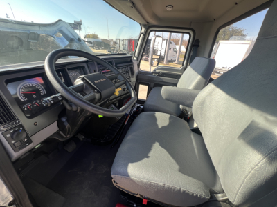 Cab interior of a new 2025 Mack MD7 truck showing steering wheel, dashboard, and front seats.