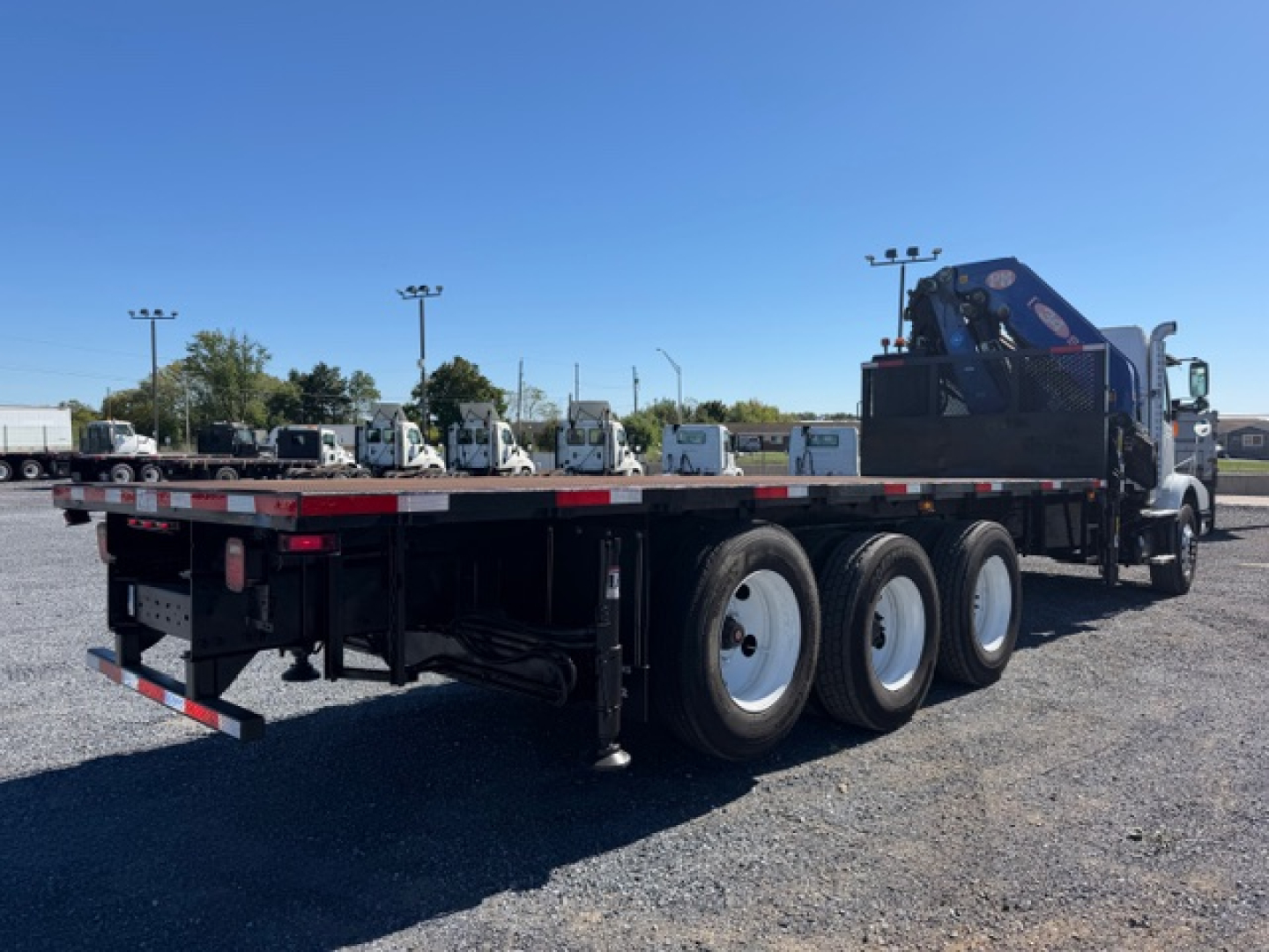 Flatbed truck with crane on a tri-axle chassis and blue crane mounted at rear, Volvo VHD 2006 used category trucks.