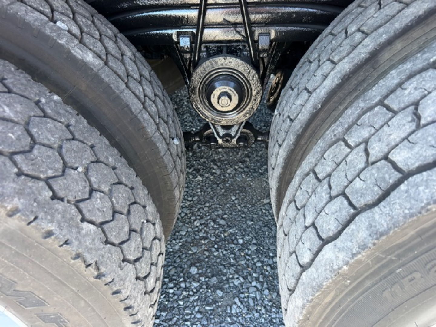 Volvo VHD truck rear undercarriage showing dual rear tires, drivetrain differential housing, and suspension components in view.