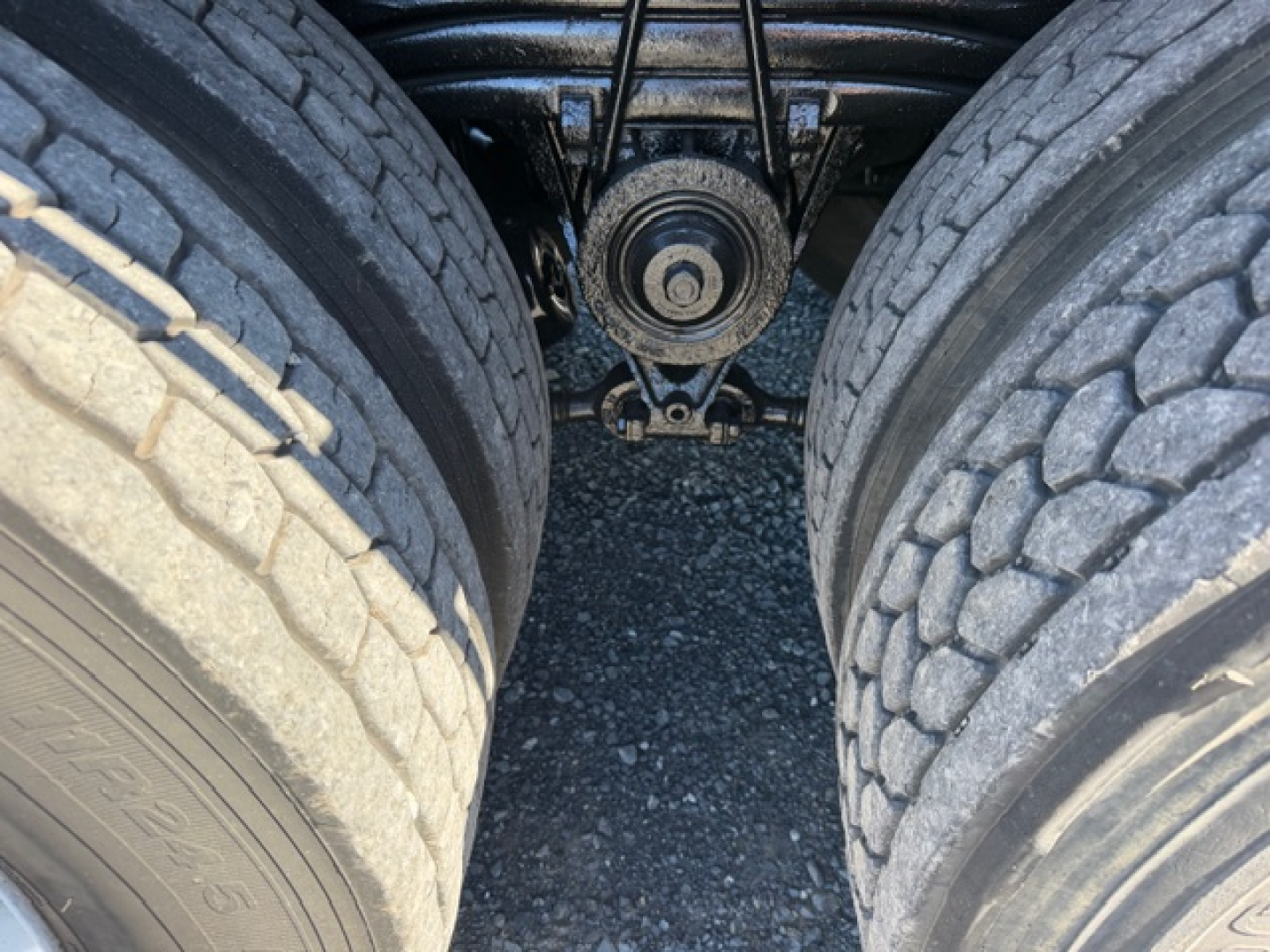 Rear view of a Volvo VHD truck undercarriage showing twin rear tires and center axle; mechanical components visible between wheels.