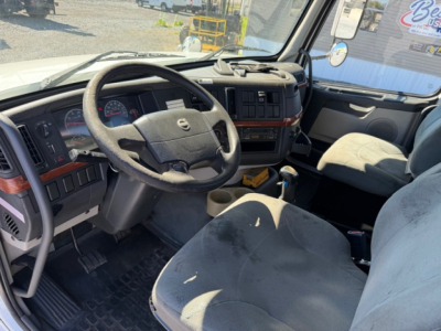 Volvo VHD truck cabin interior showing steering wheel, dashboard, and driver seat with light upholstery.