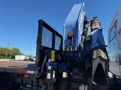 Volvo VHD crane truck rear view showing mounted hydraulic crane and control panel with warning labels