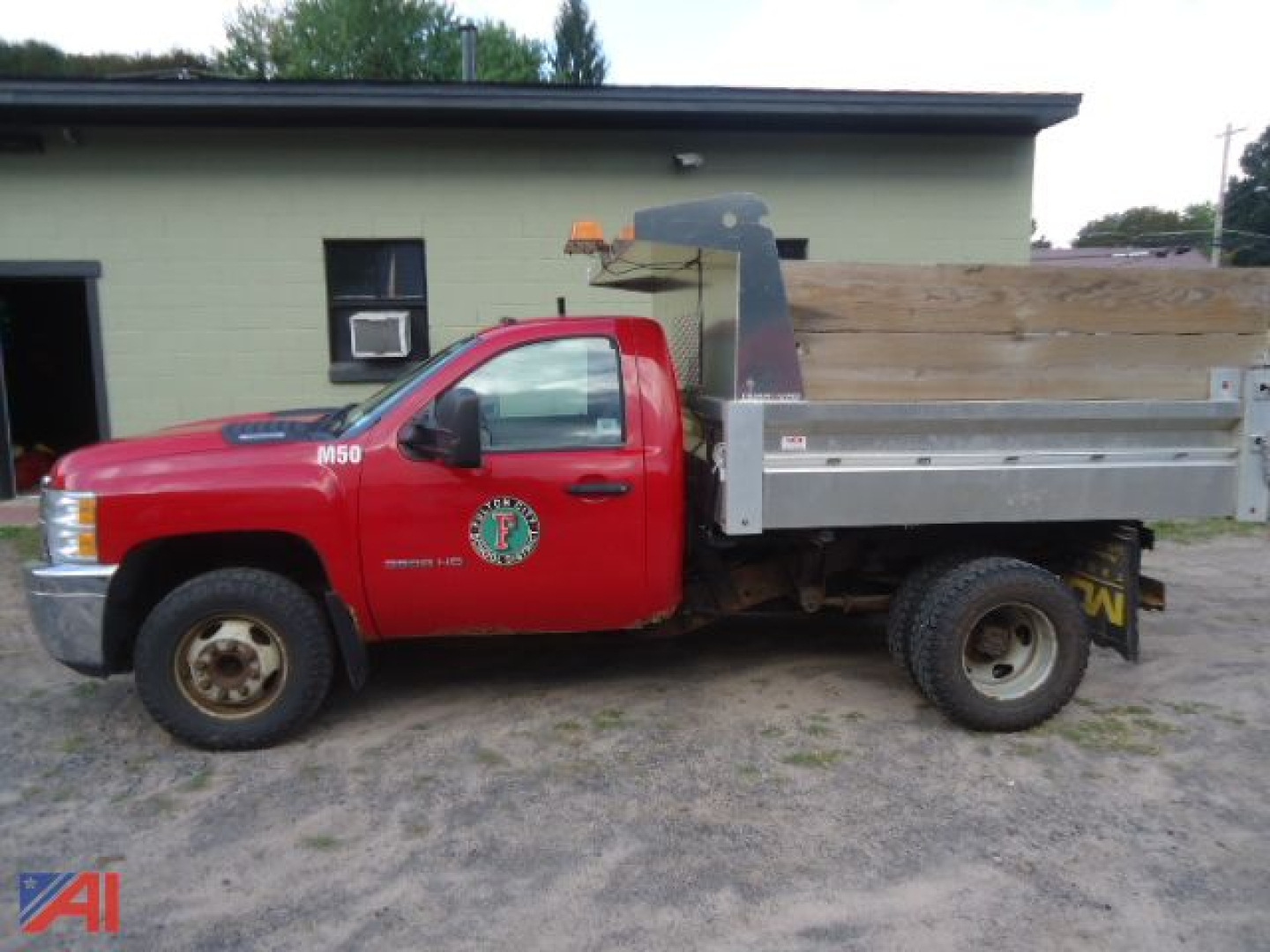 Red Chevrolet Silverado 3500HD dump truck side view showing dump bed and service decal