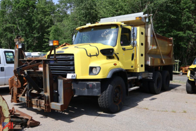 Dump truck with yellow Freightliner 114 SD chassis and plow attachment in front, side view showing sander/plow gear and dumping bed, used condition.