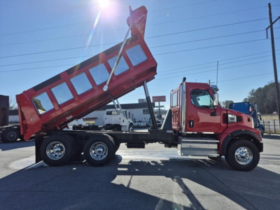 Red Western Star 47x dump truck with raised dump bed and chrome side steps, side view showing cab and rear dual-axle with hydraulic dumping mechanism.