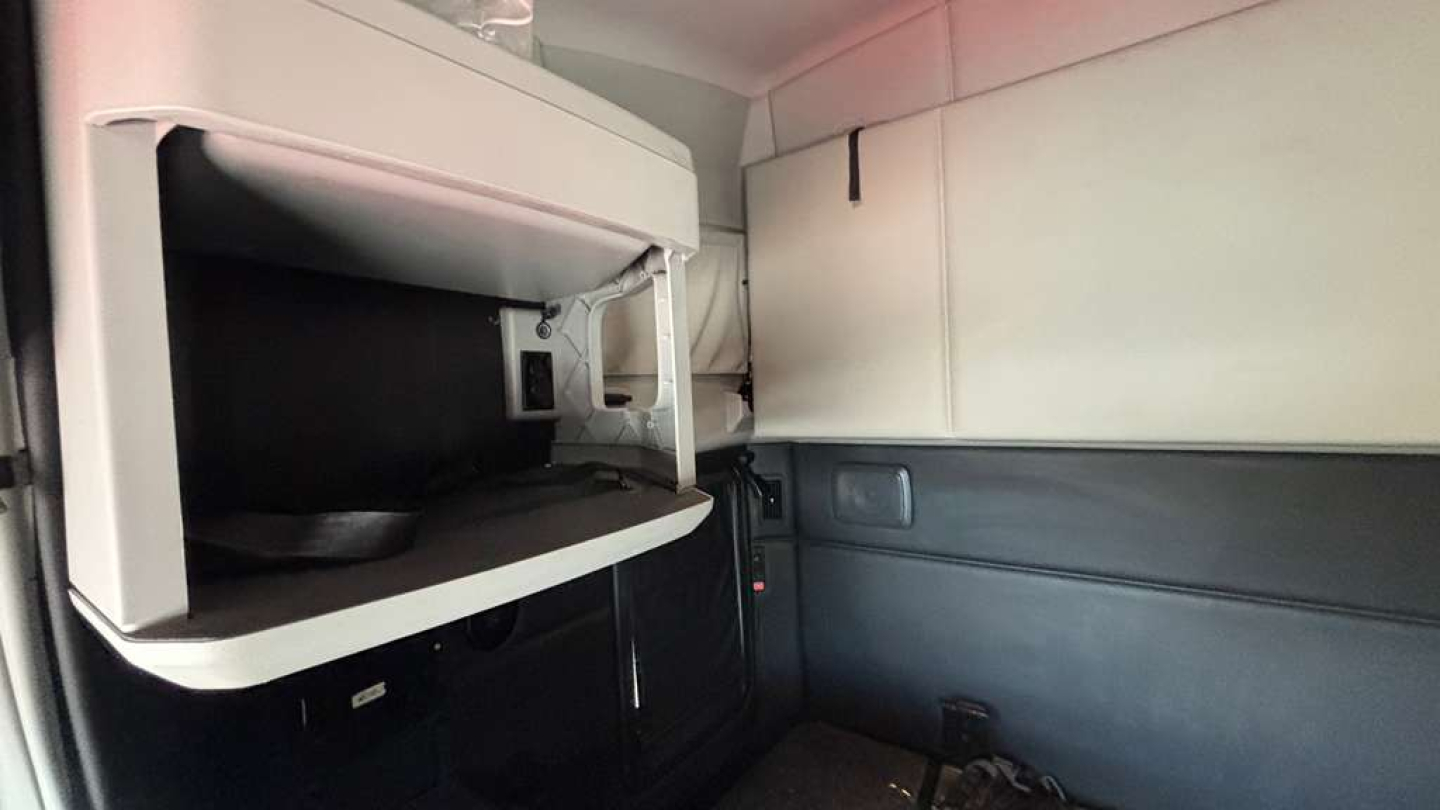 Kenworth T680 sleeper cab interior showing storage area and cab wall panels.