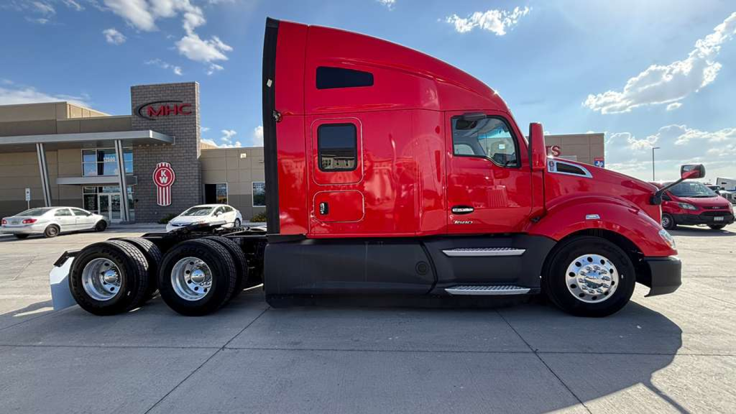 Kenworth T680 sleeper cab tractor in red side view showing triple rear axles and wheel chrome rims.